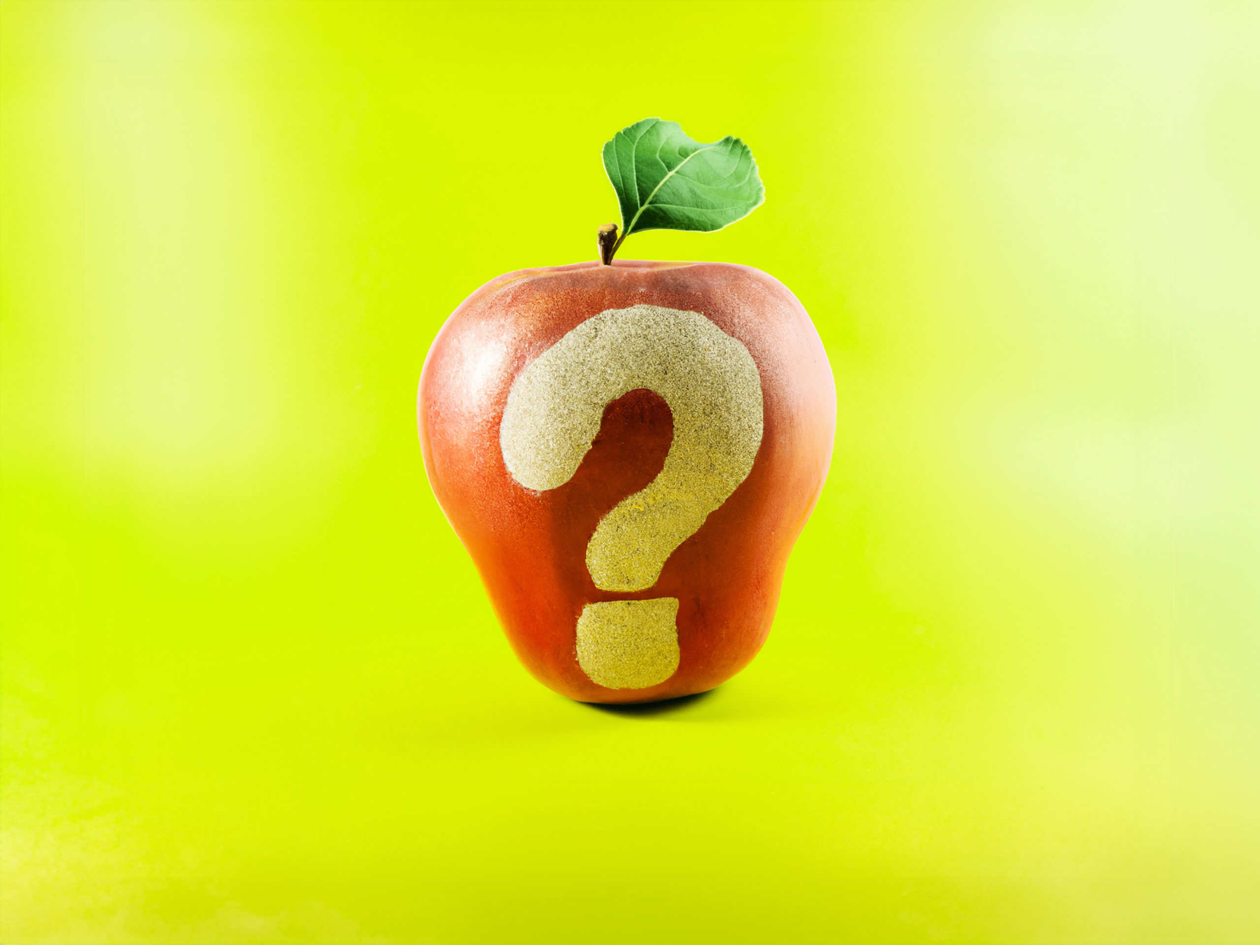Pomme rouge avec un point d'interrogation sans peau, sur fond vert pomme.