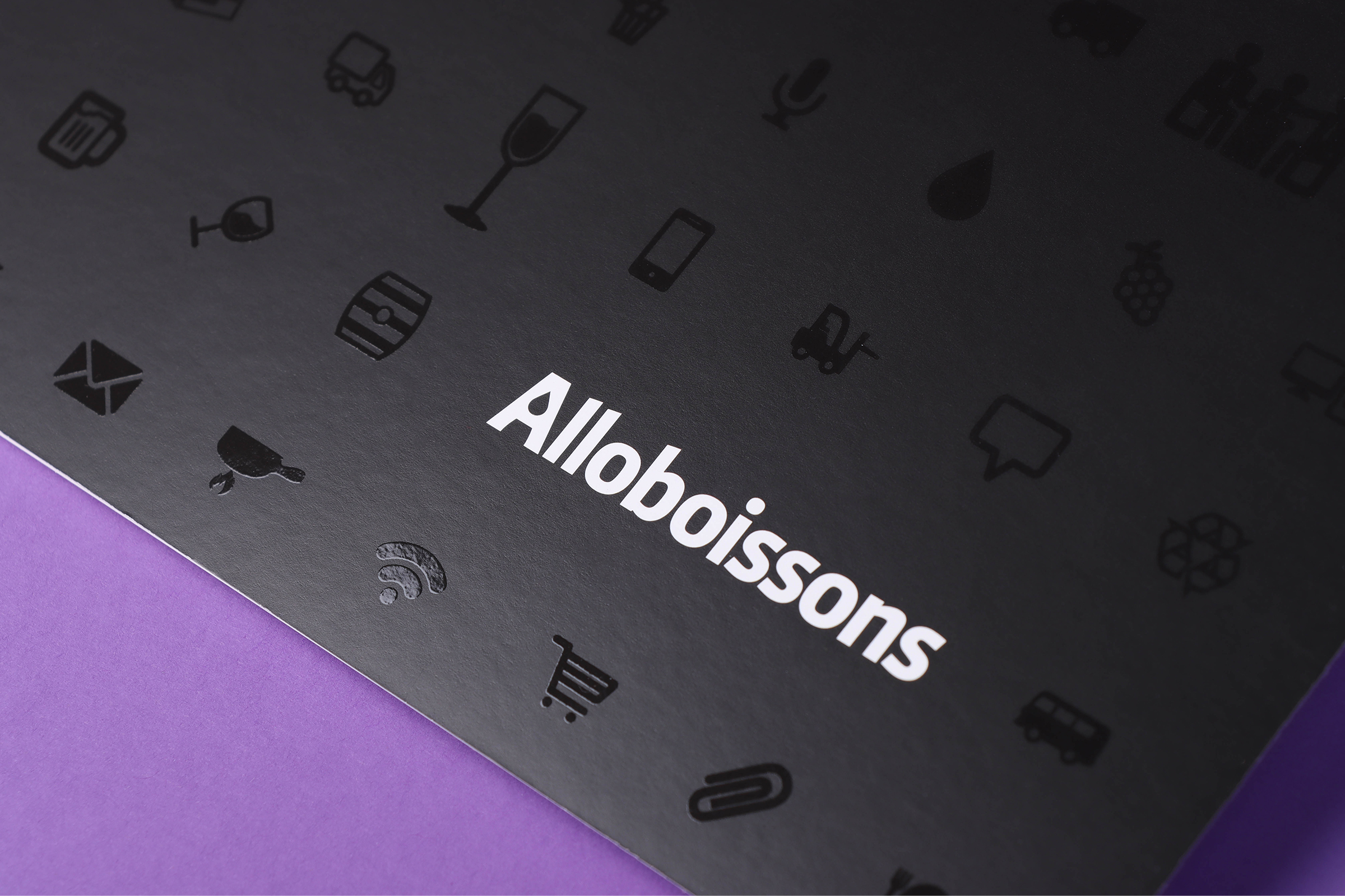 Zoom sur la couverture d'une invitation pour Alloboissons, avec encre noire et vernis sélectif brillant et tactile.